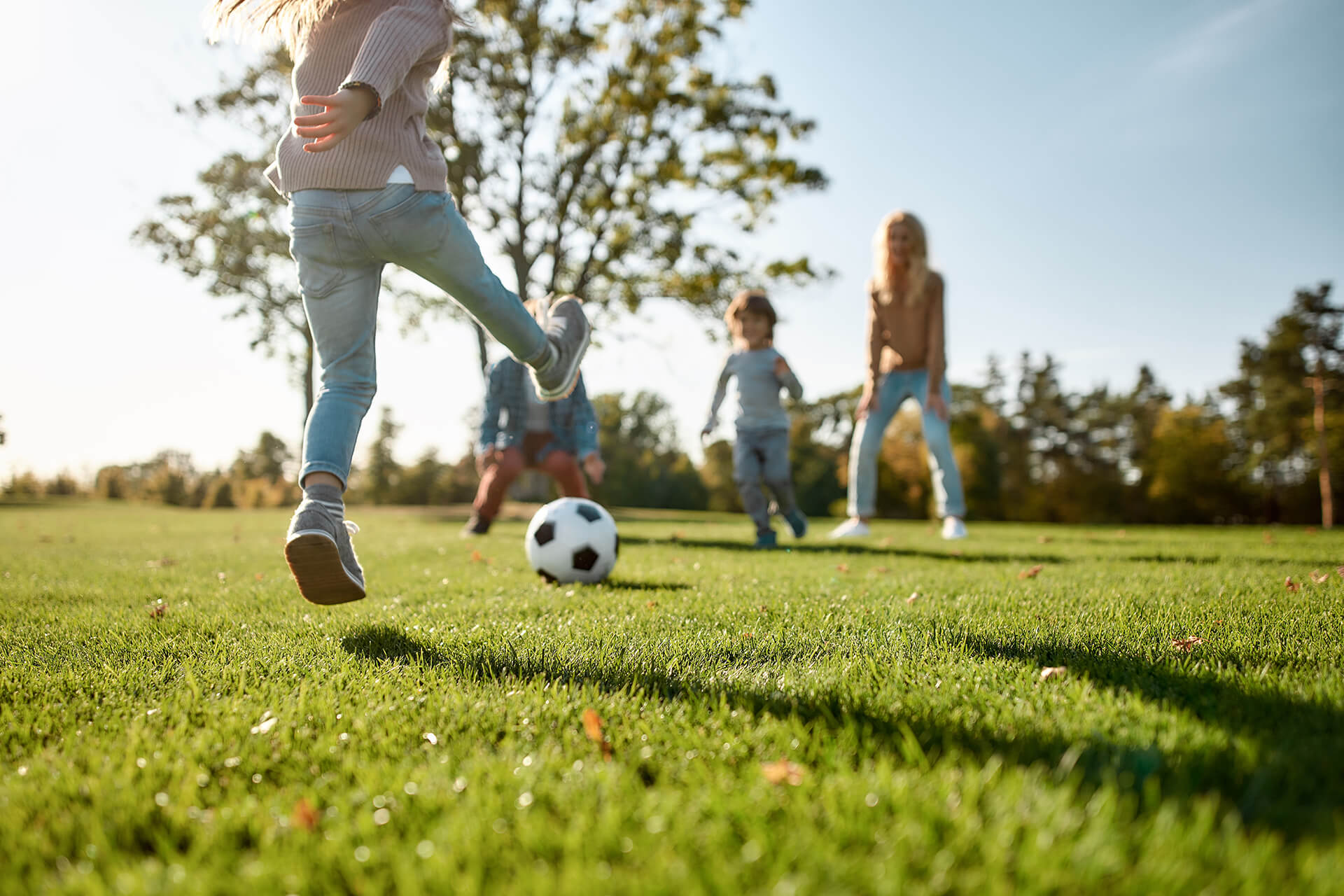 Kids outside playing soccer on a grass field